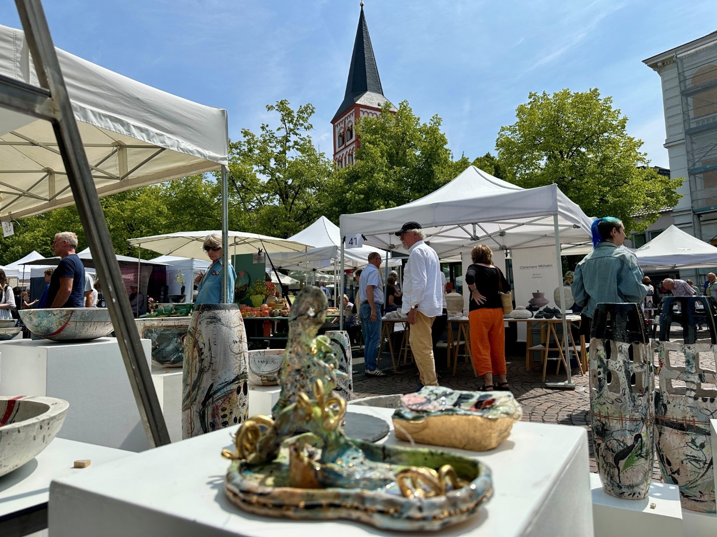 Besucher auf dem Keramikmarkt, im Vordergrund einige Keramiken von Ines Rother, Im Hintergrund die Kirche Sankt Servatius 