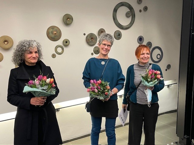 Preisträger 4. Siegburger Keramikpreis mit Blumen vor einer Wandkeramik stehend