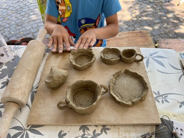 Ein Tisch an dem Kinder töpfern 