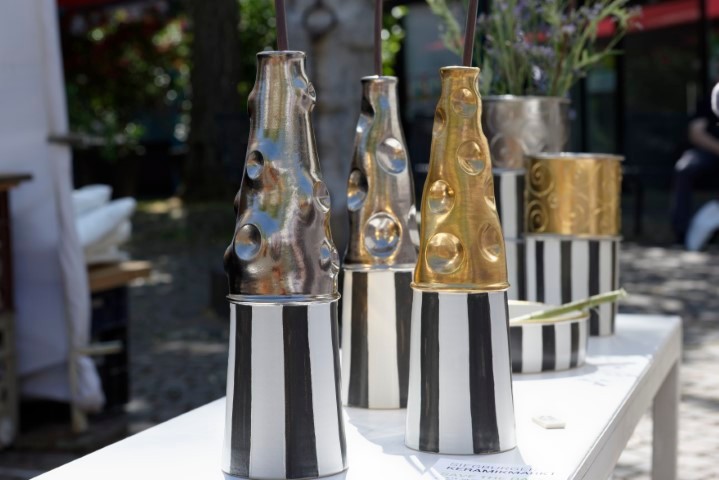 silberne schmale hohe Vasen mit Blumen 