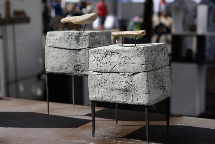 graue kastenförmige Keramikobjekte auf kleine schwarzen Beinen