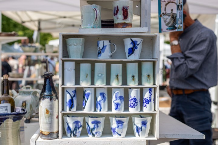 ein weißes Regal mit blau weißen Keramikbechern und Tassen