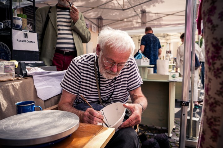 Der Keramiker Russel Coates bemalt seine Keramikschale