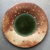 Eine Figur aus Ton liegt auf einem Elefanten