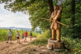Holzstatue an einem Wanderweg